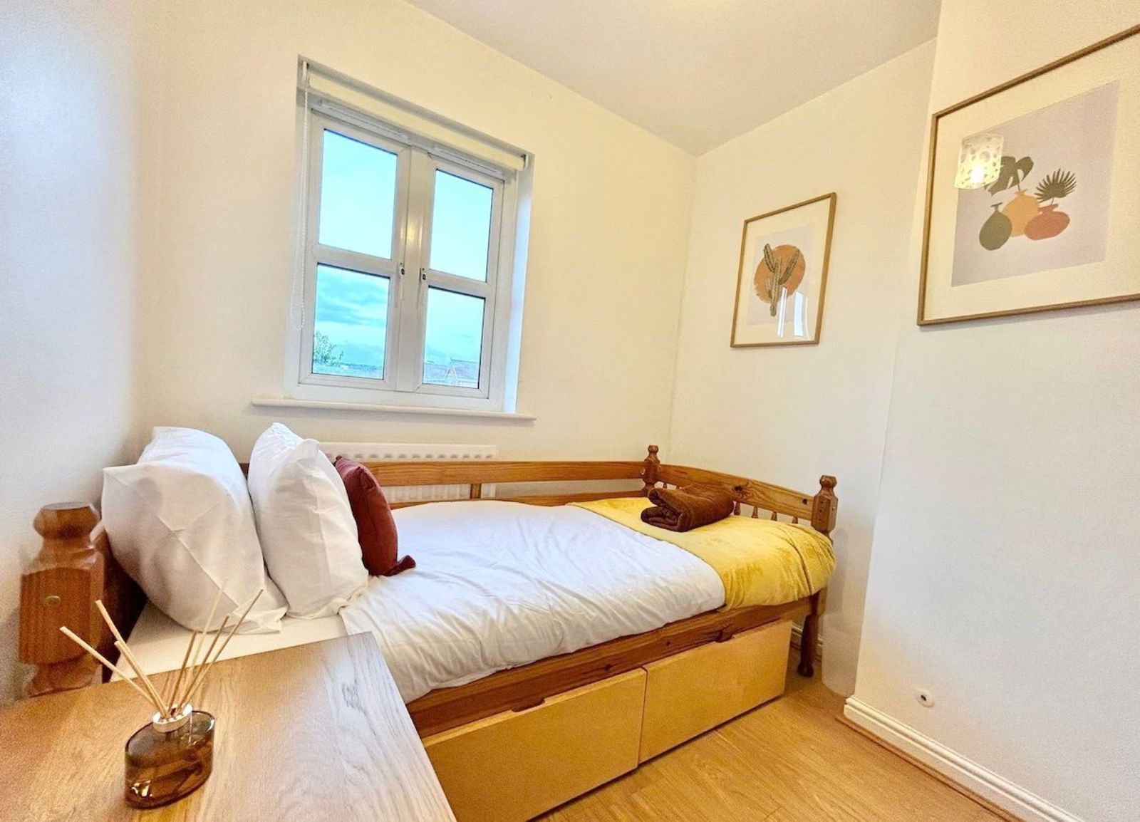 Third bedroom — single bed, side table, framed art, view to the front