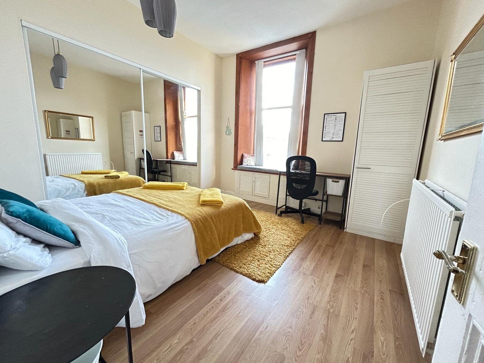 Bedroom with mirrored wardrobe and a work-from-home desk by the sash window